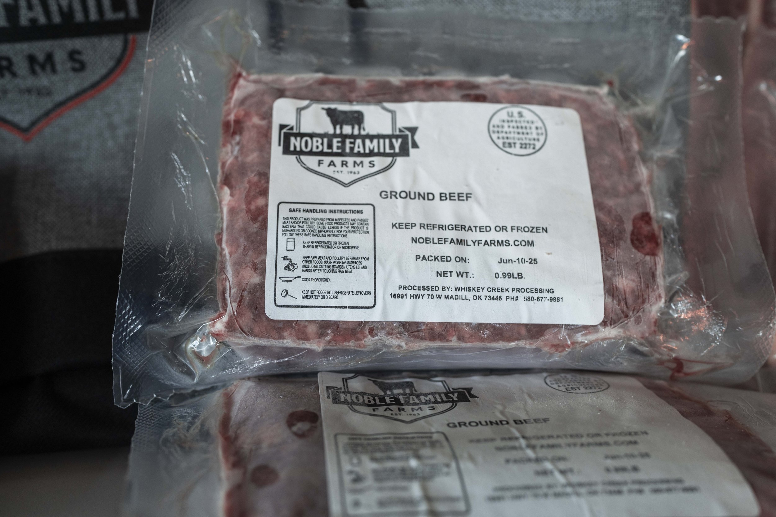 Ground beef packaging from Noble Family Farms, featuring safe handling instructions and storage recommendations. The label indicates a net weight of 0.99 lbs and a packaging date of June 10, 2025.