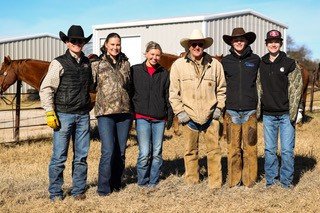 family (2) Group of five cowboys and cowgirls standing outdoors on a ranch, dressed in western attire, with horses and barn structures in the background. The scene captures a sunny day on a ranch, highlighting the cowboy culture and lifestyle.